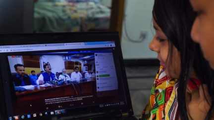 Pakistani children look at a computer screen showing a screen grab of a press conference attended by provincial minister Shaukat Yousafzai and streamed live on social media, in Islamabad on June 15, 2019.