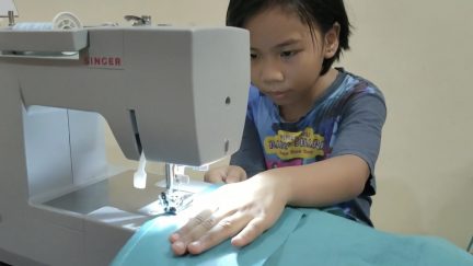Malaysian girl sewing ppe