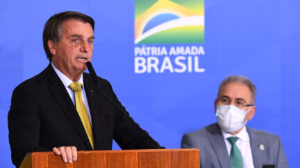 Brazilian President Jair Bolsonaro (L) speaks near Health Minister Marcelo Queiroga
