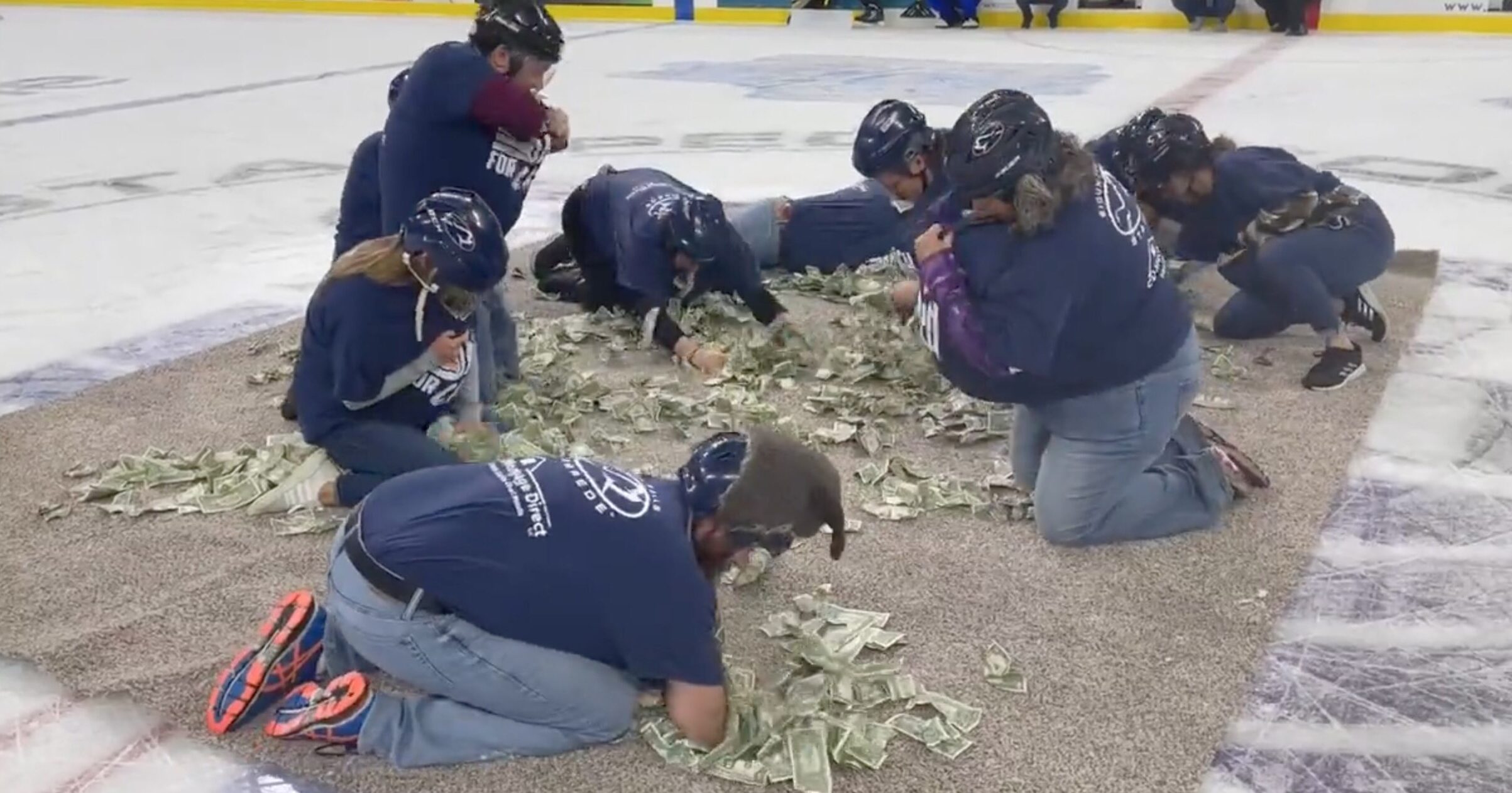 WATCH: A Hockey Team Made a Bunch of Teachers Scrounge Around on Their Knees Picking Up $1 Bills to Fund Their Classes