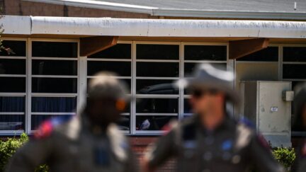 Police officers stand outside the Robb Elementary School in Uvalde, Texas, on May 25, 2022. - The tight-knit Latino community of Uvalde was wracked with grief Wednesday after a teen in body armor marched into the school and killed 19 children and two teachers, in the latest spasm of deadly gun violence in the US. (Photo by CHANDAN KHANNA / AFP) (Photo by CHANDAN KHANNA/AFP via Getty Images)