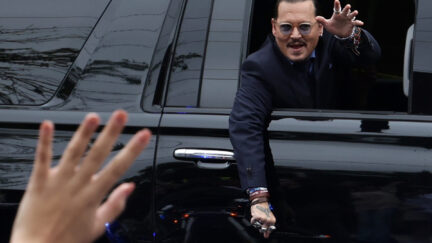 Johnny Depp waves to supporters as he leaves Fairfax Courthouse
