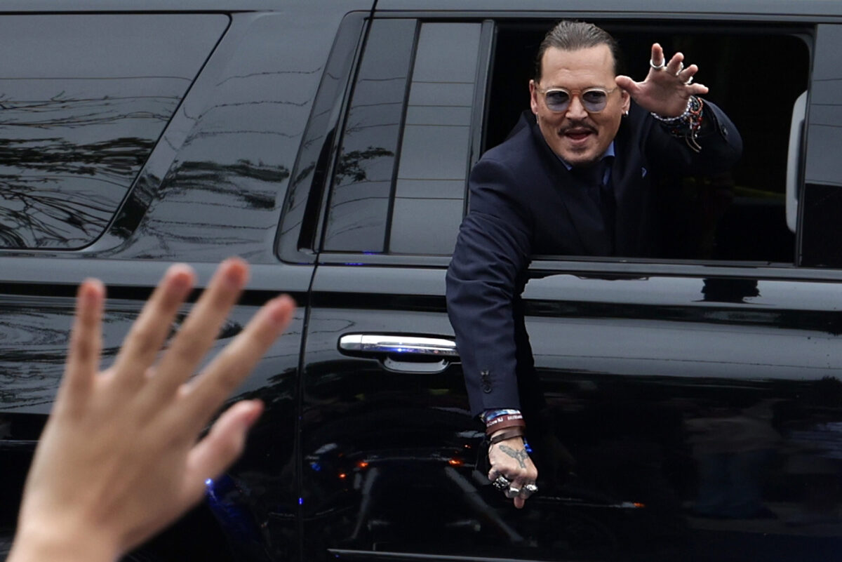 Johnny Depp waves to supporters as he leaves Fairfax Courthouse