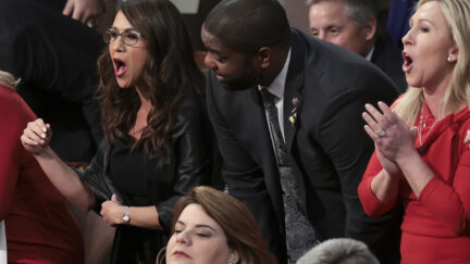 Rep. Lauren Boebert, R-Colo., left, Rep. Byron Donalds, R-Fla., and Rep. Marjorie Taylor Greene, R-Ga., stand with fellow lawmakers as they listen to President Joe Biden deliver his State of the Union address to a joint session of Congress at the Capitol, Tuesday, March 1, 2022, in Washington. (Win McNamee, Pool via AP)