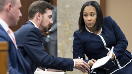 Fulton County District Attorney Fani Willis, right, talks with a member of her team during proceedings to seat a special purpose grand jury in Fulton County, Georgia, on May 2, 2022, to look into the actions of former President Donald Trump and his supporters who tried to overturn the results of the 2020 election. The hearing took place in Atlanta.