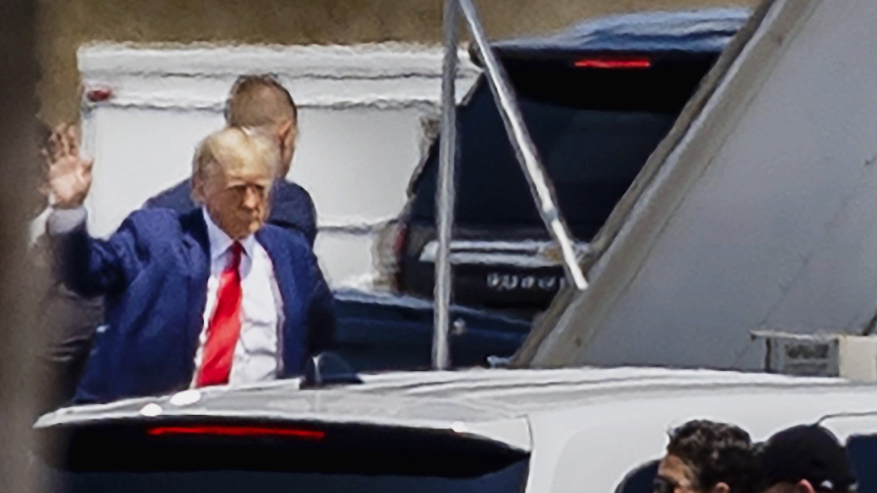 Donald Trump waves as he heads to the stairs to board his private plane at the Palm Beach International Airport in West Palm Beach, Fla., on Monday, April 3, 2023.