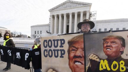 Protesters hold their banners in front of the U.S. Supreme Court, Thursday, Feb. 8, 2024, in Washington.