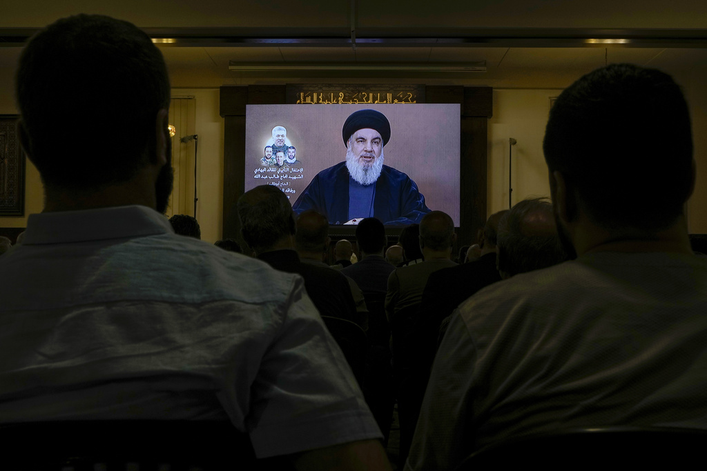 Hezbollah supporters watch a speech given by Hezbollah leader Sayyed Hassan Nasrallah on a screen during a ceremony to commemorate the death of senior Hezbollah commander Taleb Sami Abdullah, 55, who was killed last week by an Israeli strike in south Lebanon, in the southern Beirut suburb of Dahiyeh, Lebanon, Wednesday, June 19, 2024.  