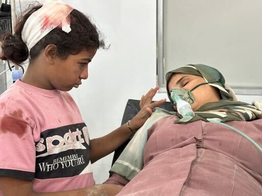 A little girl comforts her mother after they were injured during an attack north of Gaza's Nuseirat camp.