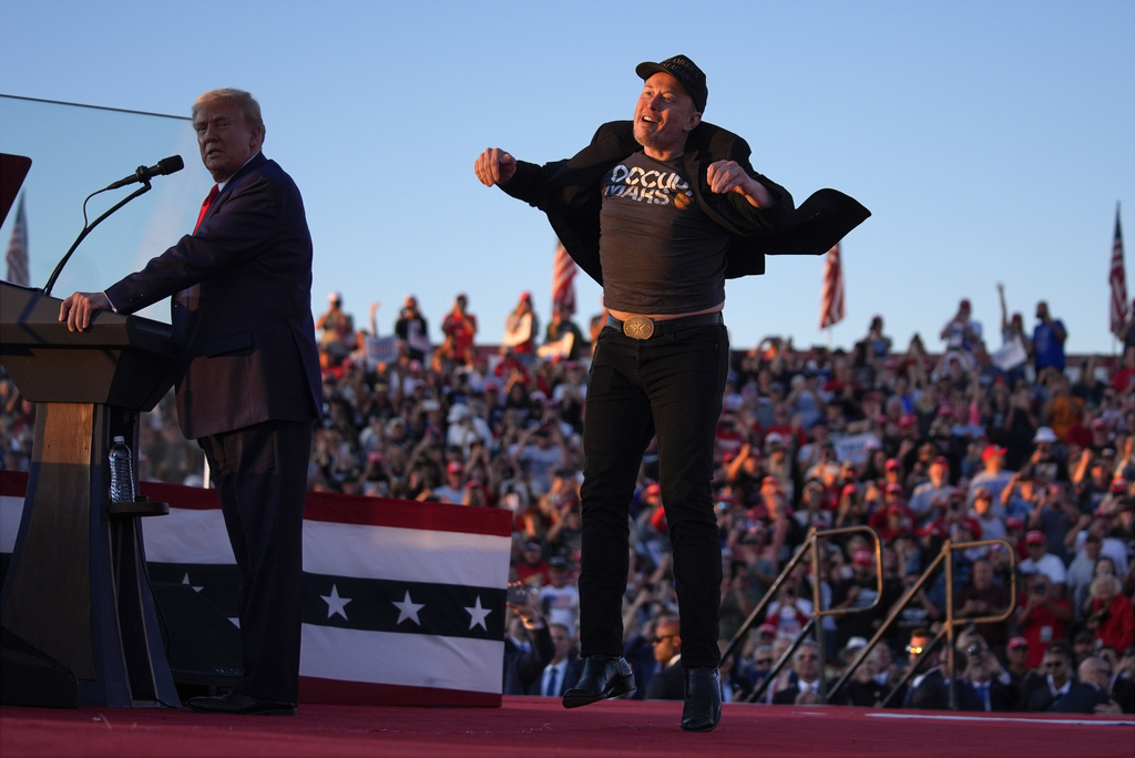 FILE - Elon Musk jumps on the stage as Republican presidential nominee former President Donald Trump speaks at a campaign rally at the Butler Farm Show, Saturday, Oct. 5, 2024, in Butler, Pa.