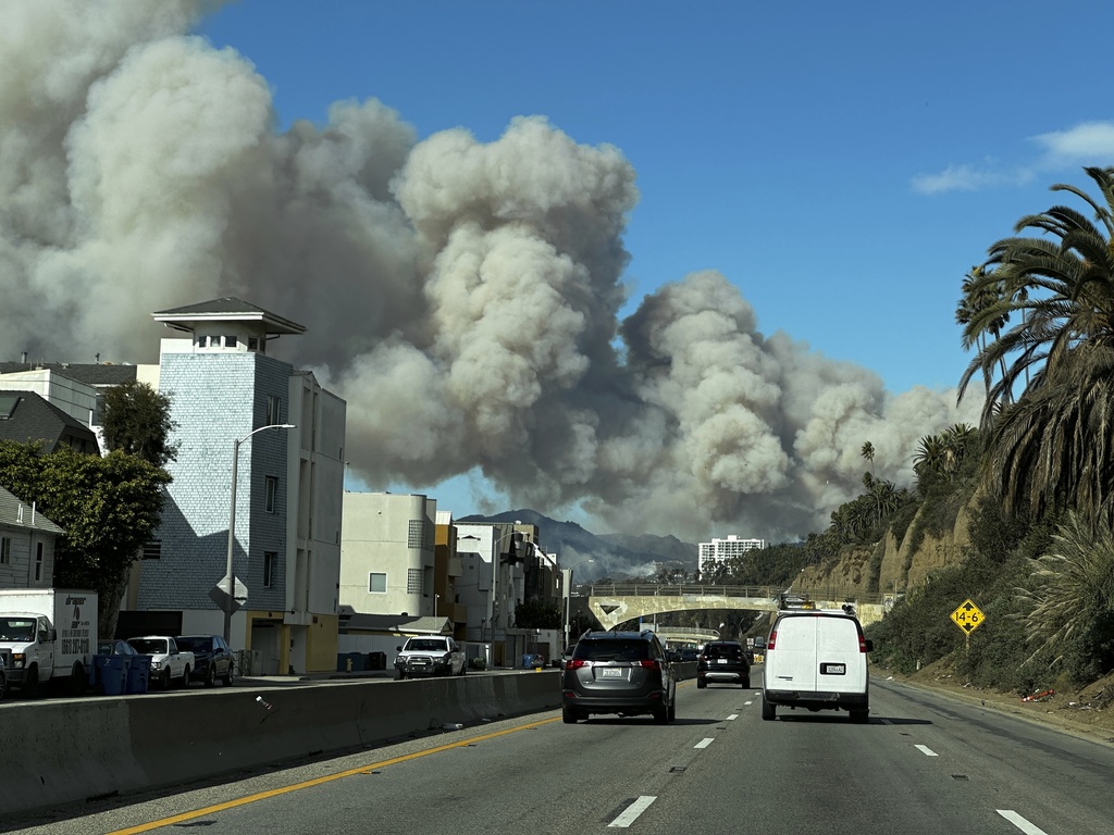 Heavy smoke from a brush fire in the Pacific Palisades rises over the Pacific Coast Highway in Santa Monica, Calif., on Tuesday, Jan. 7, 2025.