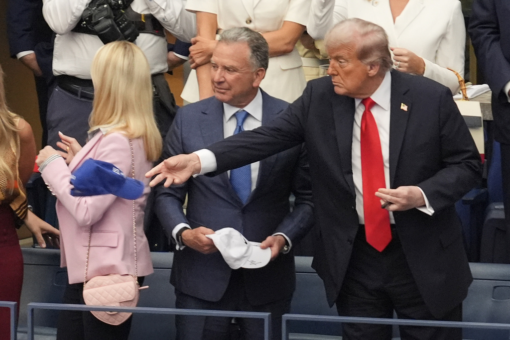 President Donald Trump tosses a hat during the US Open tennis men's singles final Sunday, Sept. 7, 2025, in Flushing, N.Y. 
