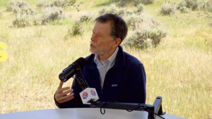 ken burns sitting at a microphone
