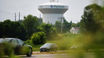 water tower with cars in foreground